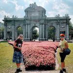 Vstupná brána do Madridu Puerta de Alcalá a rozkvitnutý záhon ruží s klientami v lete